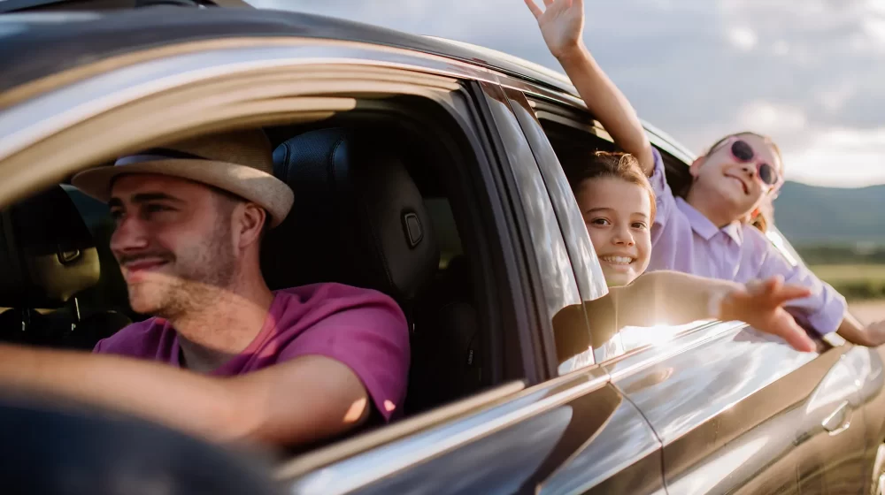 padre e hijas viajando en auto felices