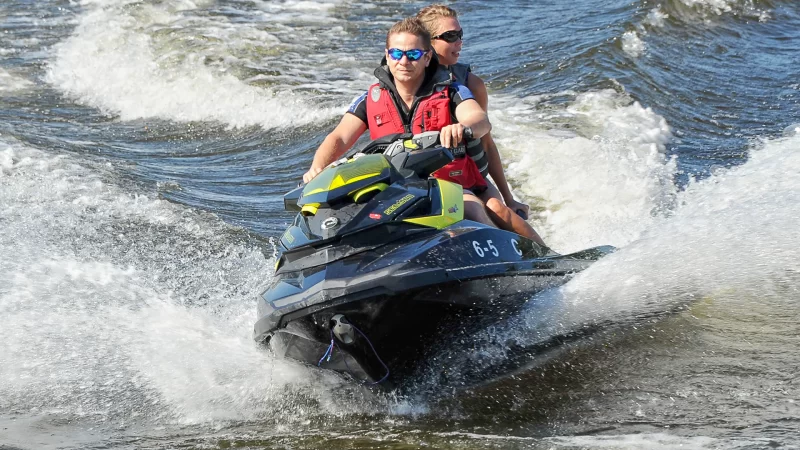 hombre y mujer andando en moto de agua en el mar